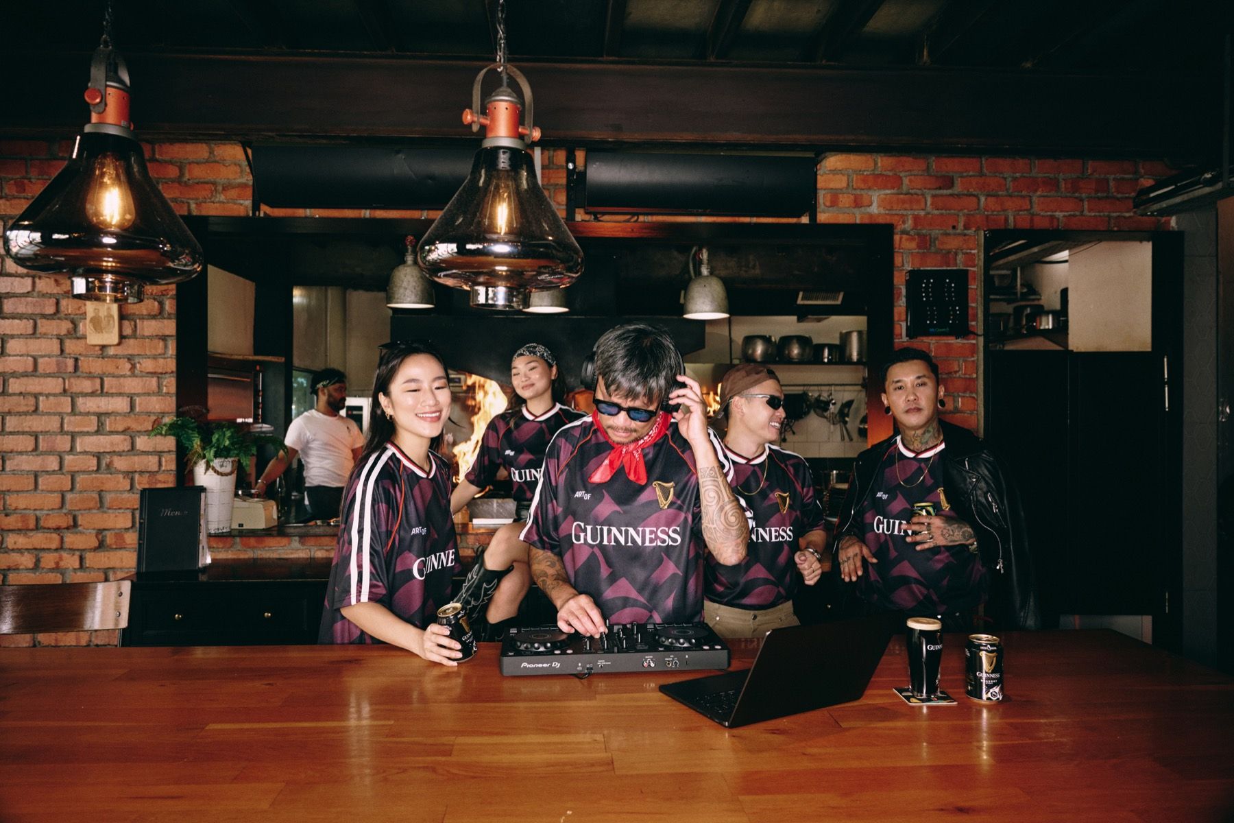 Seven friends in the jersey gathered around a bar table with pints