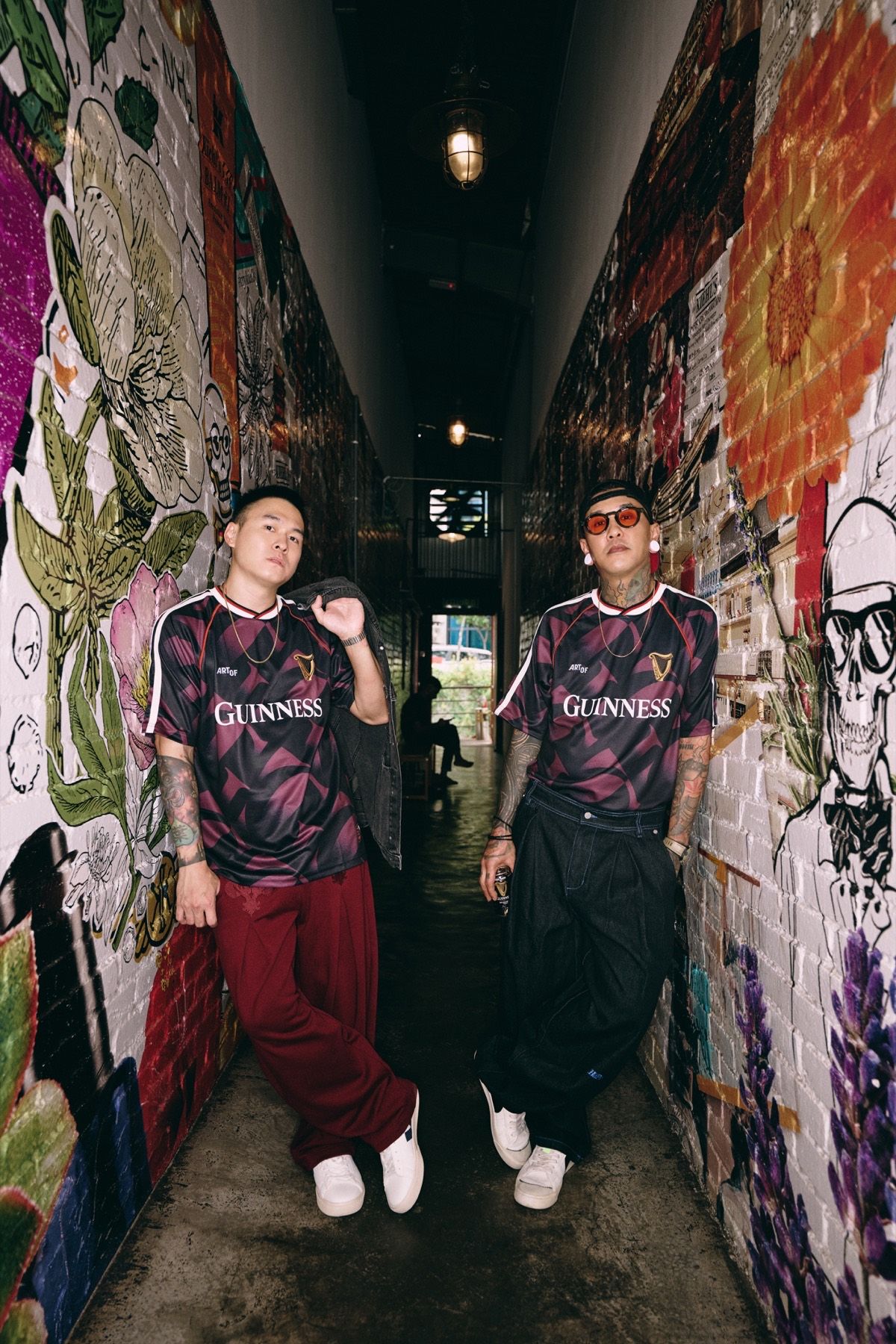 Two models in a narrow alley covered in murals