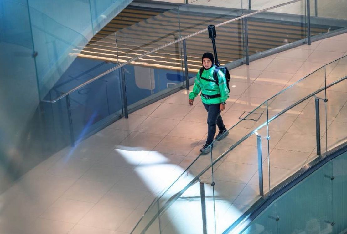 A mapper crossing a glass walkway seen from above