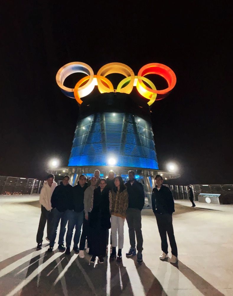 The team under the Olympic rings at night