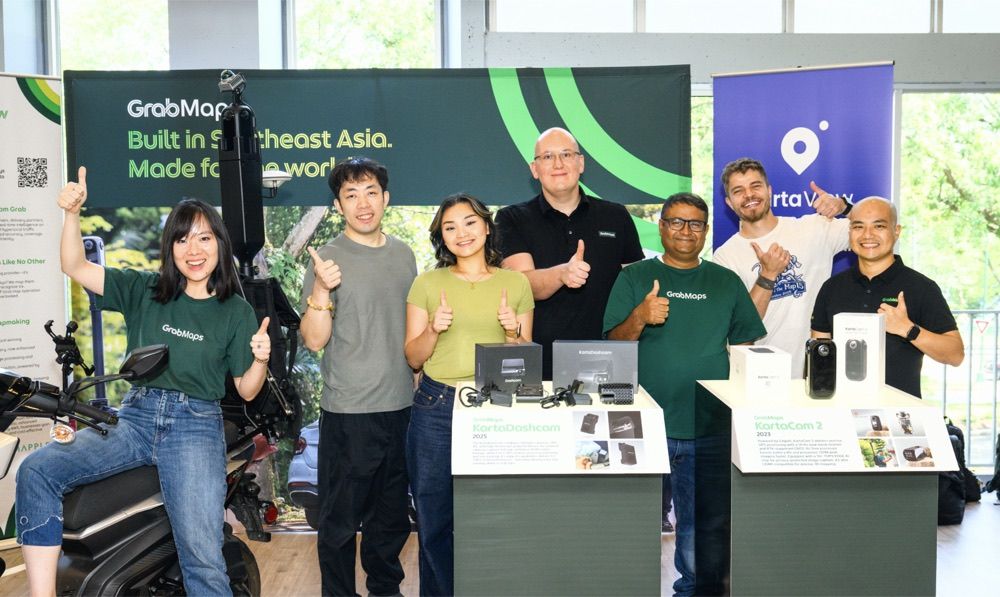 GrabMaps booth team giving a thumbs up