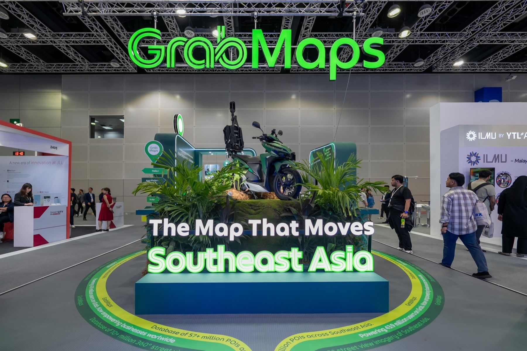 The finished booth: a Grab bike on a mossy rock under a glowing GrabMaps sign reading The Map That Moves Southeast Asia