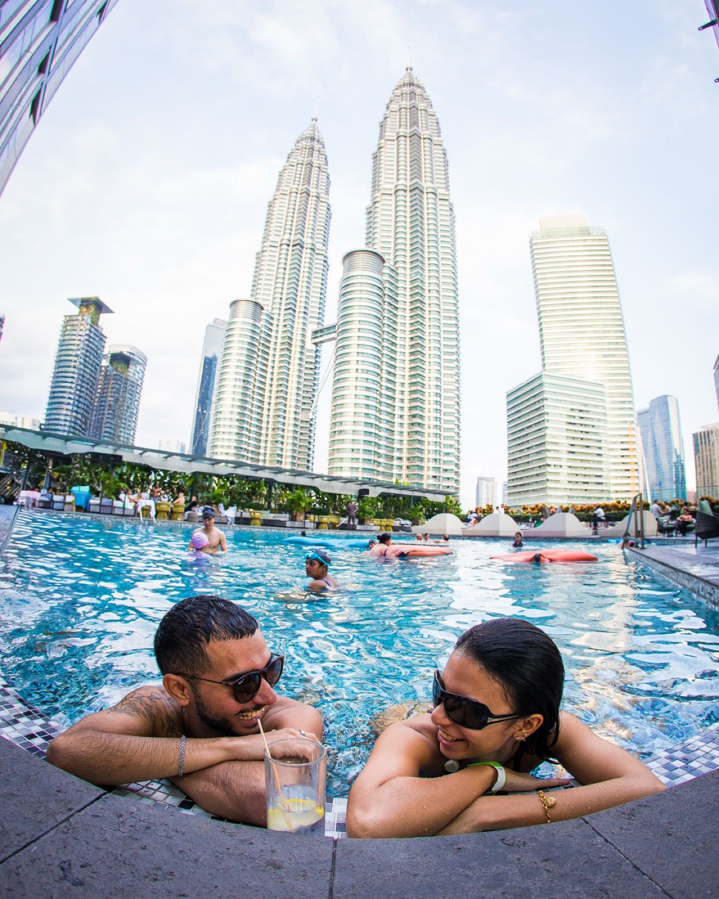 Two guests in the pool with the Petronas Towers behind